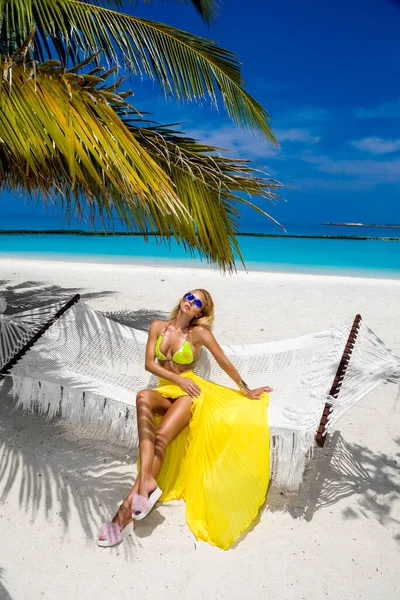 马尔代夫岛上热带海滩上穿着黄色泳衣的优雅的晒黑的女人 性感的女模特在海滩上的吊床上放松 马尔代夫的风景 豪华旅游 — 图库照片