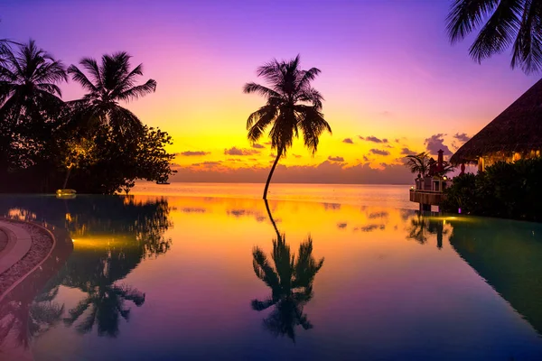 在马尔代夫岛上落日落山 有豪华的水上别墅度假胜地和木制码头 美丽的天空 云彩和有棕榈背景的海滩作为暑假和旅行的背景 — 图库照片