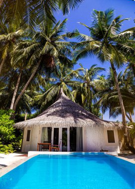 Landscape on Maldives island, luxury water villas resort with pool. Beautiful sky and ocean and beach with palms background for summer vacation holiday and travel concept. Luxury travel.
