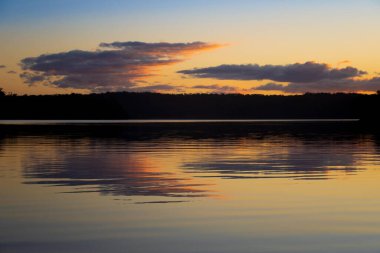 Huzur gölünde güzel bir gün batımı. Su, doğayı yansıtır.