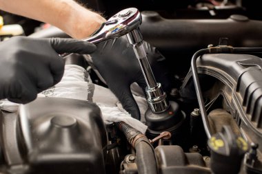 Elleri soket anahtarlı cırcır. Araba yağı filtresi değiştiriliyor. DIY motor yağını değiştir. Araç bakımında. Filtre değişimi. Yağ filtresi kapağı