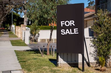 For sale sign on black board near the resedential building. Property Real estate concept