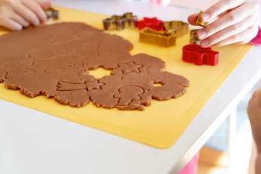Seçici odaklanma. Çocuklar çeşitli Noel kurabiyeleriyle zencefilli kurabiye yapıyorlar. Zencefilli ekmek hamuru. Aile Noel eğlencesi anları