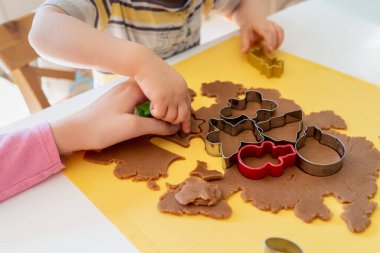 Seçici odaklanma. Çocuklar çeşitli Noel kurabiyeleriyle zencefilli kurabiye yapıyorlar. Zencefilli ekmek hamuru. Aile Noel eğlencesi anları