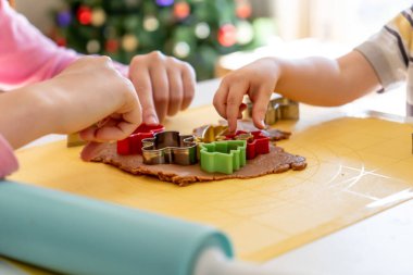 Seçici odaklanma. Çocuklar çeşitli Noel kurabiyeleriyle zencefilli kurabiye yapıyorlar. Zencefilli ekmek hamuru. Aile Noel eğlencesi anları