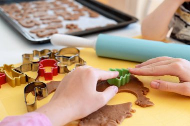 Seçici odaklanma. Çocuklar çeşitli Noel kurabiyeleriyle zencefilli kurabiye yapıyorlar. Zencefilli ekmek hamuru. Aile Noel eğlencesi anları