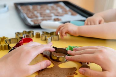 Seçici odaklanma. Çocuklar çeşitli Noel kurabiyeleriyle zencefilli kurabiye yapıyorlar. Zencefilli ekmek hamuru. Aile Noel eğlencesi anları