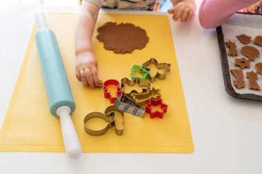 Seçici odaklanma. Çocuklar çeşitli Noel kurabiyeleriyle zencefilli kurabiye yapıyorlar. Zencefilli ekmek hamuru. Aile Noel eğlencesi anları