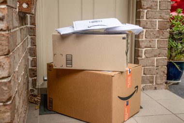 Sydney, Avustralya - 2021-12-03 Amazon ana kutuları ve zarfları bir apartmanın ön kapısına teslim edildi. Kara Cuma Siber Pazartesi Noel Satışı Günü. Amazon Flex teslimatı
