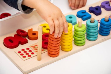 Bebeklerin erken gelişimi. Tahta yığını ve gökkuşağı renkli öğrenme oyununu say. Çocuk renk ve sayıları öğren