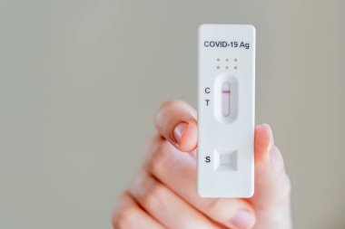 Covid-19 'un hızlı antijen test kasedini tutan eller evde yapılan hızlı teşhis testinin negatif sonucunu içeriyor.