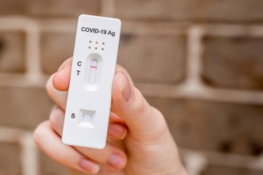 Covid-19 'un hızlı antijen test kasedini tutan eller evde yapılan hızlı teşhis testinin negatif sonucunu içeriyor.