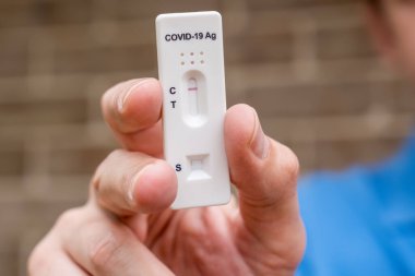 Covid-19 'un hızlı antijen test kasedini elinde tutan adam hızlı tanı testi sonucu negatif çıktı. Evde kendi kendini test etme kiti
