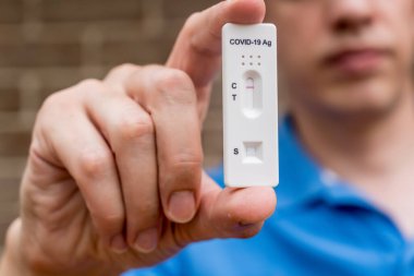 Covid-19 'un hızlı antijen test kasedini elinde tutan adam hızlı tanı testi sonucu negatif çıktı. Evde kendi kendini test etme kiti