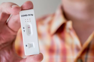 Covid-19 'un hızlı antijen test kasedini elinde tutan adam hızlı tanı testi sonucu negatif çıktı. Evde kendi kendini test etme kiti
