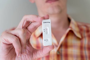 Covid-19 'un hızlı antijen test kasedini elinde tutan adam hızlı tanı testi sonucu negatif çıktı. Evde kendi kendini test etme kiti