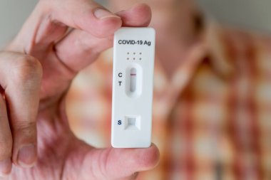 Covid-19 'un hızlı antijen test kasedini elinde tutan adam hızlı tanı testi sonucu negatif çıktı. Evde kendi kendini test etme kiti