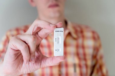 Covid-19 'un hızlı antijen test kasedini elinde tutan adam hızlı tanı testi sonucu negatif çıktı. Evde kendi kendini test etme kiti