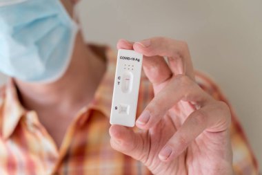 Covid-19 'un hızlı antijen test kasedini elinde tutan adam hızlı tanı testi sonucu negatif çıktı. Evde kendi kendini test etme kiti