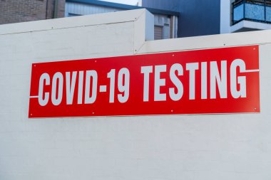 Duvarda COVID-19 test kliniği tabelası var. Coronavirus PCR tıbbi testi