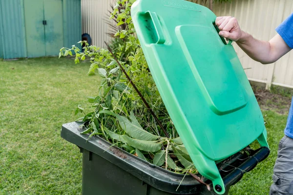 装满花园垃圾的绿色垃圾箱 春天来了为创造更好的环境而进行垃圾回收利用 — 图库照片