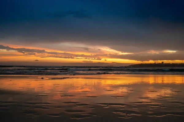 Naturskön Solnedgång Havets Sandstrand Med Stadens Siluett Vid Horisonten Vacker — Stockfoto