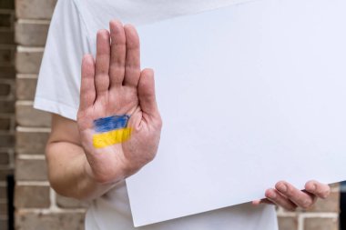 Elinde Ukrayna bayrağı ve beyaz boş poster kağıdı vardı. Rus Ukrayna savaş çatışması tezahürü protesto kavramı uydurma