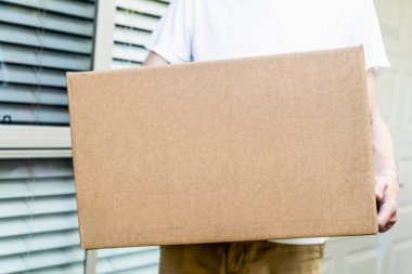 Paket kutusu, kurye tarafından konutun ön kapısına teslim edildi. Çevrimiçi alışveriş nakliyesi. Şablonu düzenle