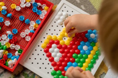 Yürüyen çocuk tahta mozaiği oynuyor. Erken çocuk gelişimi. Güzel motor beceriler. Öğrenme ve yaratıcılık