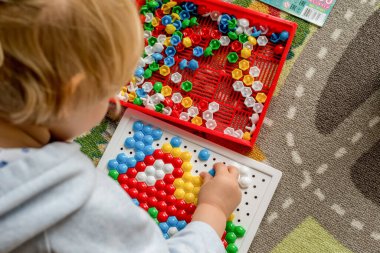 Yürüyen çocuk tahta mozaiği oynuyor. Erken çocuk gelişimi. Güzel motor beceriler. Öğrenme ve yaratıcılık