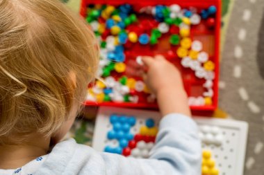 Yürüyen çocuk tahta mozaiği oynuyor. Erken çocuk gelişimi. Güzel motor beceriler. Öğrenme ve yaratıcılık