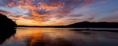 Huzur gölünde güzel bir gün batımı. Su, doğayı yansıtır.