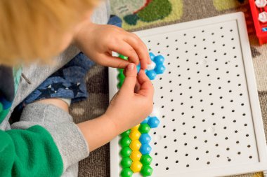 Yürüyen çocuk tahta mozaiği oynuyor. Erken çocuk gelişimi. Güzel motor beceriler. Öğrenme ve yaratıcılık