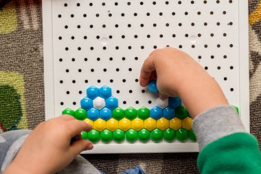 Yürüyen çocuk tahta mozaiği oynuyor. Erken çocuk gelişimi. Güzel motor beceriler. Öğrenme ve yaratıcılık