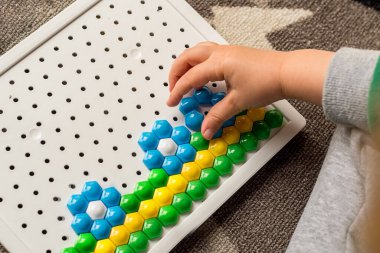 Yürüyen çocuk tahta mozaiği oynuyor. Erken çocuk gelişimi. Güzel motor beceriler. Öğrenme ve yaratıcılık