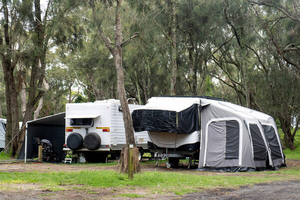 Various RV caravan camper on a campsite at the holiday caravan park surrounding by nature. Camping vacation
