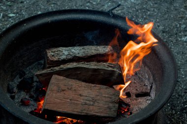 Kamp ateşi yakacak odun ateşinde yanıyor. Kamp hayatı. Açık hava eğlencesi. Seçici odak