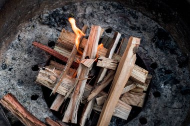 Yakacak odun ateşiyle bir kamp ateşi yakmak. Kamp yaşam tarzı.