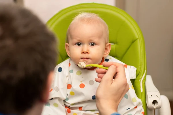 Pai Alimentando Bebê Uma Cadeira Alta Com Colher Cheia Mingau — Fotografia de Stock