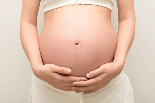 stock image Pregnant woman is embracing her belly.