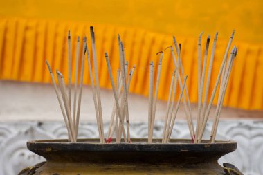 Tütsü çubukları yakmak ve tütsü kabında tütsü tüttürmek. Ayutthaya, Tayland 'daki Tapınakta Buda' ya dua etmek için tütsü.