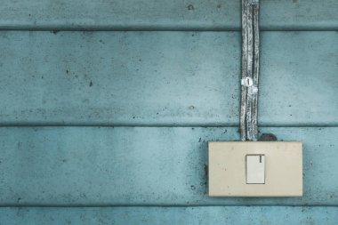 Eski mavi ahşap duvarlı eski elektrik düğmesi.