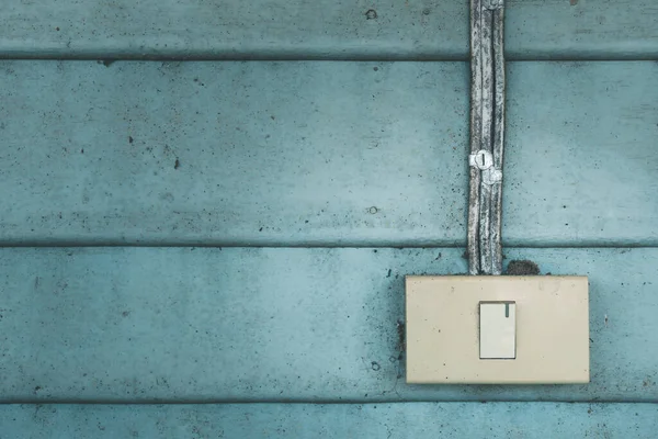 Eski mavi ahşap duvarlı eski elektrik düğmesi.