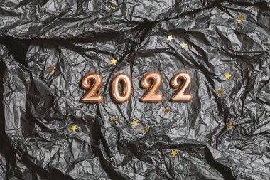 Siyah buruşuk arka planda, yıldızlı 2022 numara. Top view Yeni Yıl Kutlama Konsepti. 