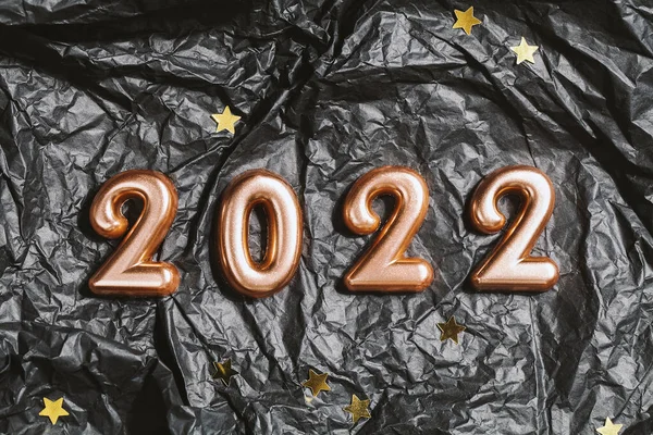 Números 2022 sobre fondo arrugado negro con estrellas. arriba ver concepto de celebración de año nuevo. — Foto de Stock