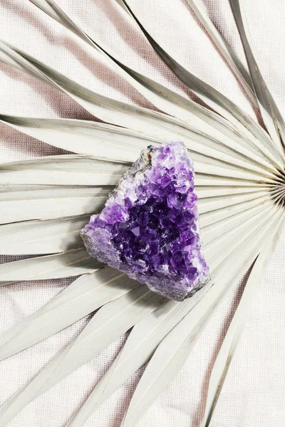 ヤシの葉の上に紫色のアメジスト結晶を捨て 儀式用の魔法の岩 精神的な練習 瞑想のための魔法の岩 — ストック写真