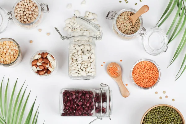 Veganský zdroj proteinů. Fazole, hrách, cizrna, čočka, fazole, arašídy ve sklenici na bílém pozadí. — Stock fotografie