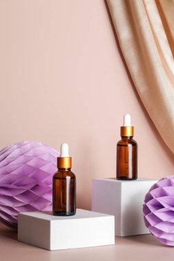 Bej arka planda podyum sahnesinde serum esansı. Tekstil ve bal peteği kağıt dekor ile. Cilt kozmetik. 