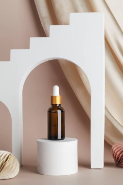 Podyum sahnesinde serum esansı, bej arka planda geometrik kemerler, tekstil ve bal peteği dekoru. Tatil kavramında cilt kozmetiği
