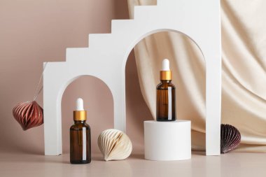 Podyum sahnesinde serum esansı, bej arka planda geometrik kemerler, tekstil ve bal peteği dekoru. Tatil kavramında cilt kozmetiği
